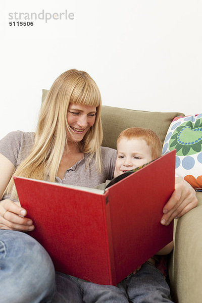 Mutter und Sohn beim gemeinsamen Lesen auf dem Sofa