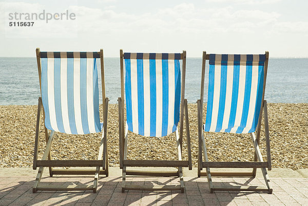 Gestreifte Liegestühle am Strand