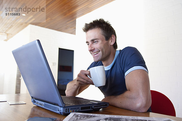 Mann mit Laptop und Tasse Kaffee