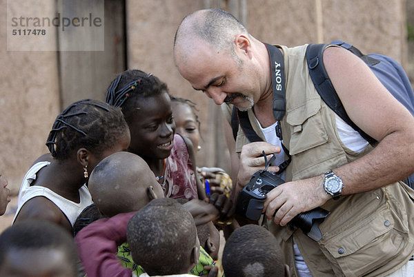 Afrika  Burkina Faso  Fotograf mit digitale Bildern in lokalen Menschen im Dorf