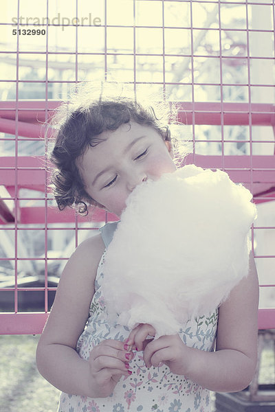 Kleines Mädchen genießt Zuckerwatte mit geschlossenen Augen