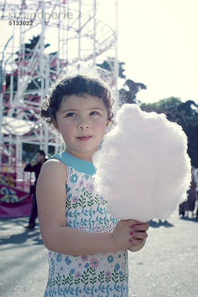 Kleines Mädchen mit Zuckerwatte auf der Messe  Portrait