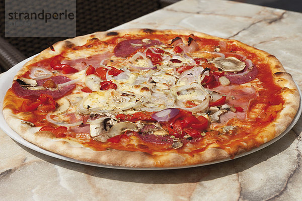 Pizza Ariecchino mit Mozarella-Käse  Champignons  Kochschinken  Salami und Zwiebeln zum Anfassen