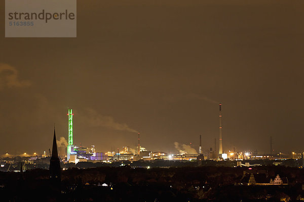 Deutschland  Nordrhein-Westfalen  Duisburg  Blick auf beleuchteten grünen Turm und Industrieanlage bei Nacht