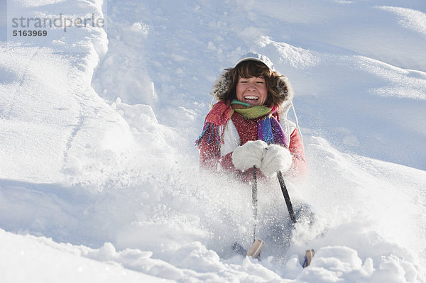 Österreich  Salzburger Land  Flachau  Junge Frau beim Schlittenfahren im Schnee