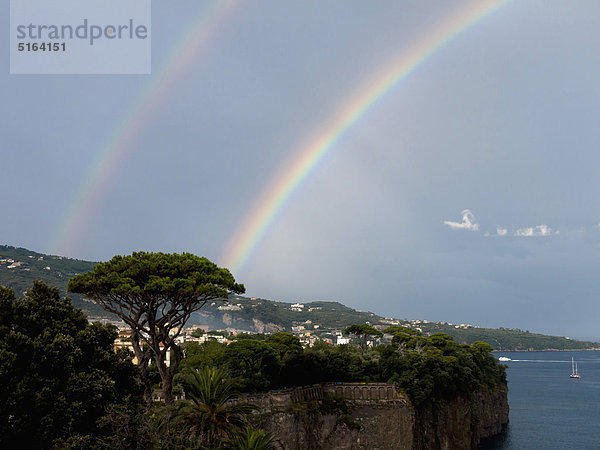 Süditalien  Amalfiküste  Piano di Sorrento  Blick auf schönen Regenbogen im Meer mit Klippe im Vordergrund