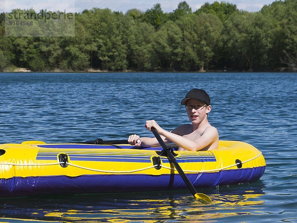 Junge im Schlauchboot Rafting am See  lächelnd  Portrait