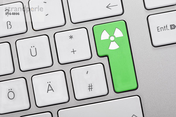 Nahaufnahme von Computertasten mit Atomsymbol auf grüner Taste
