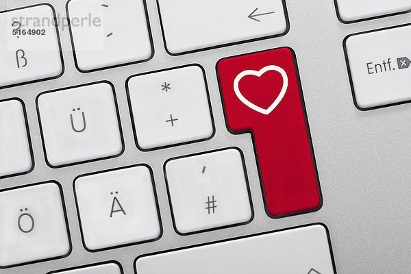 Nahaufnahme von Computertasten mit Herzsymbol auf roter Taste