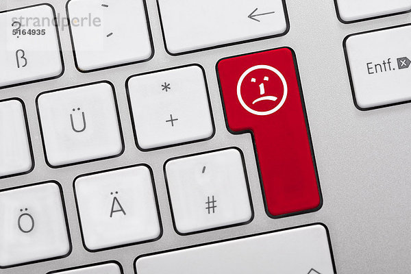 Abbildung der Tastatur mit roter Taste mit traurigem Gesicht  Nahaufnahme