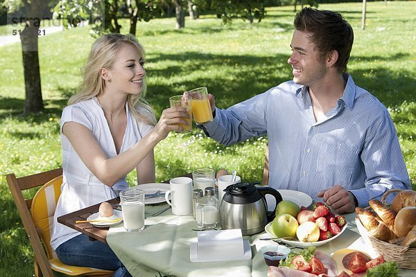 Junges Paar frühstückt im Park