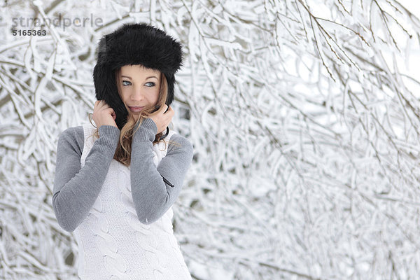 Junge Frau mit Mütze im Schnee