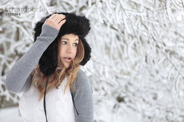 Junge Frau mit Mütze im Schnee