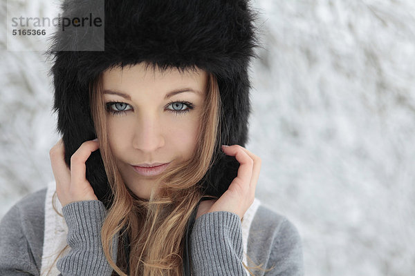 Junge Frau mit Mütze im Schnee