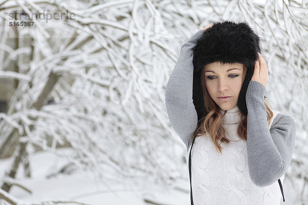 Junge Frau mit Mütze im Schnee