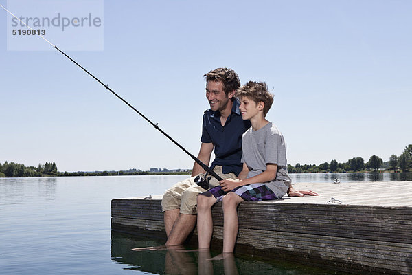 Vater und Sohn beim gemeinsamen Angeln am Steg