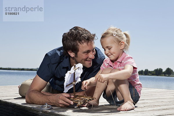 Vater und Tochter spielen auf dem Dock