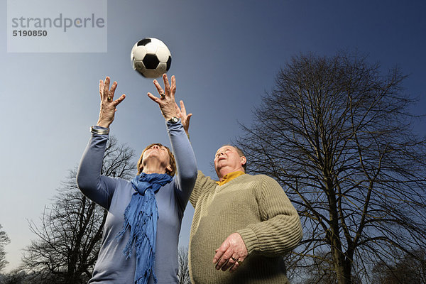 Älteres Paar spielt mit Fußball