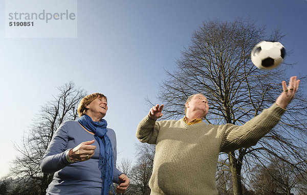 Älteres Paar spielt mit Fußball