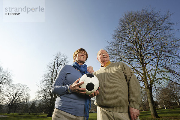 Älteres Paar spielt mit Fußball