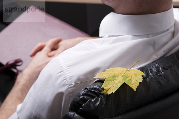 Blatt am Stuhl des Geschäftsmannes geklebt