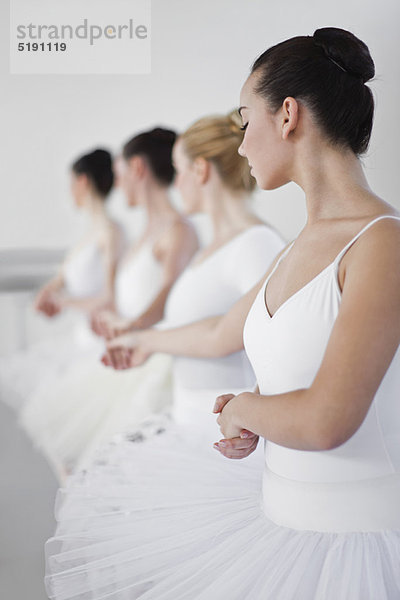 Balletttänzerinnen halten sich im Studio an den Händen