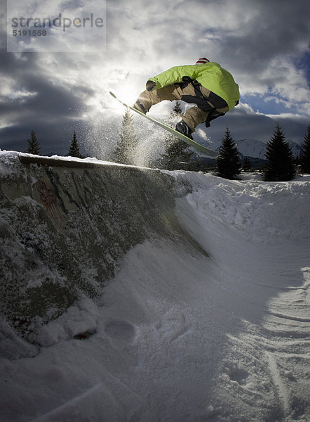 Snowboarder springen auf Halfpipe