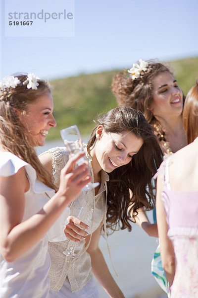 Braut trinkt Champagner mit Freunden