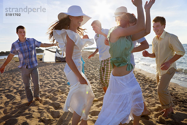 Menschen tanzen zusammen am Strand