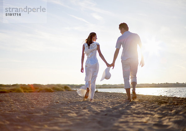 Neuvermähltes Ehepaar beim Spaziergang am Strand