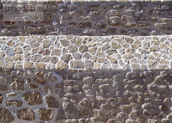 Natursteinmauer mit hellerem Absatz