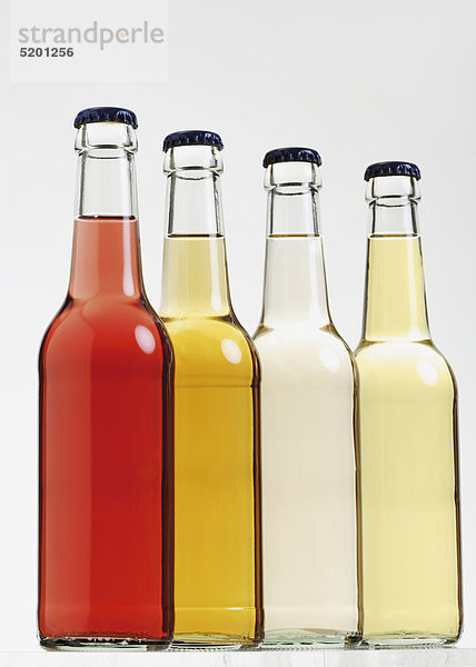 Vier Flaschen mit farbigen Biodrinks