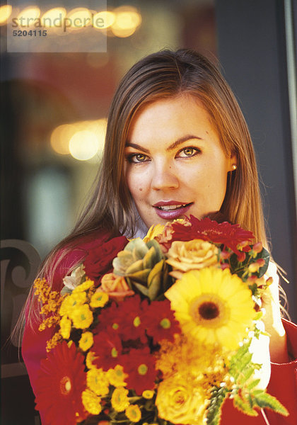 Frau mit buntem Blumenstrauß  Halbporträt
