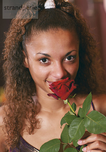 Junge Frau mit roter Rose  dunkler Teint  Porträt