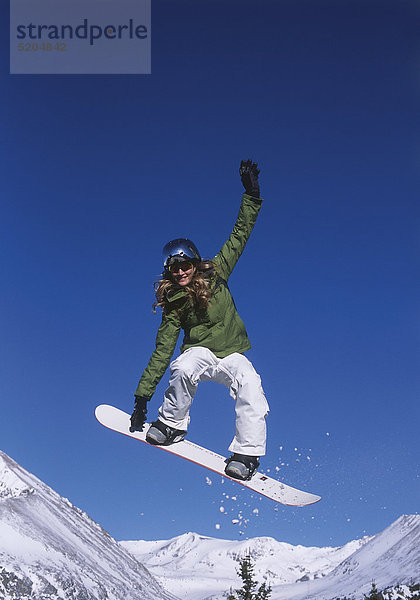 Frau auf Snowboard im Sprung