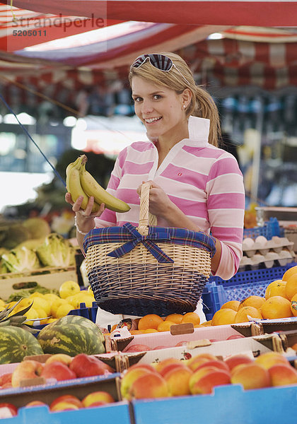 Junge Frau mit Bananen am Markt