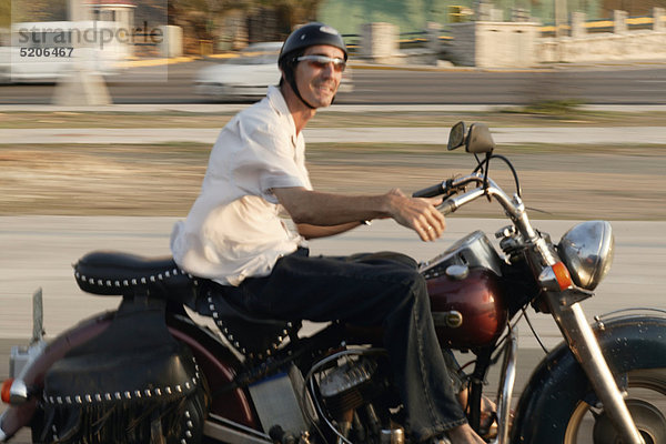 Mann fährt auf altem Motorrad  Kuba  Bewegung