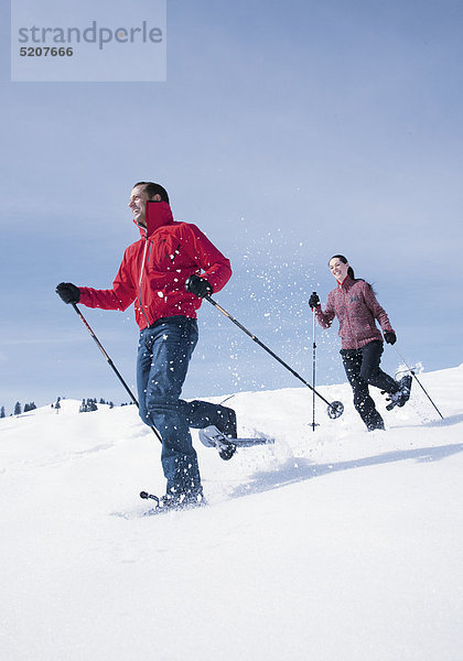 Paar beim Schneeschuhwandern  laufen bergab