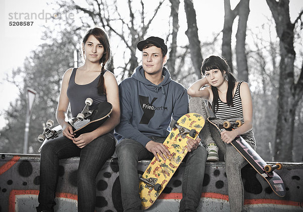 Drei Jugendliche mit Skateboards
