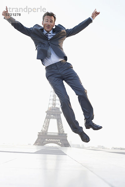 Geschäftsmann beim Springen mit dem Eiffelturm im Hintergrund  Paris  Ile-de-France  Frankreich