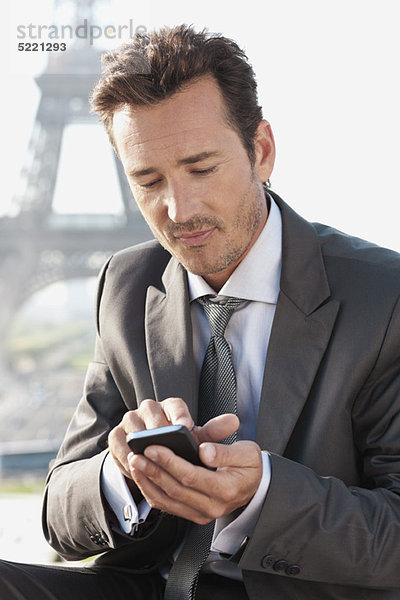 Geschäftsmann mit Handy und Eiffelturm im Hintergrund  Paris  Ile-de-France  Frankreich