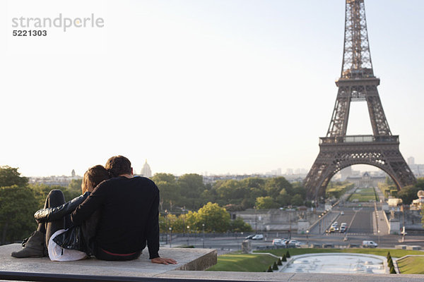 Paar sitzend zusammen mit dem Eiffelturm im Hintergrund  Jardins du Trocadero  Paris  Ile-de-France  Frankreich