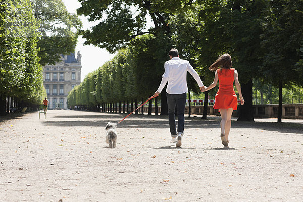 Paar im Garten mit einem Welpen  Terrasse De l'Orangerie  Jardin des Tuileries  Paris  Ile-de-France  Frankreich