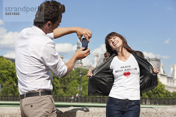 Mann fotografiert eine Frau mit einem Handy  Seine River  Paris  Ile-de-France  Frankreich