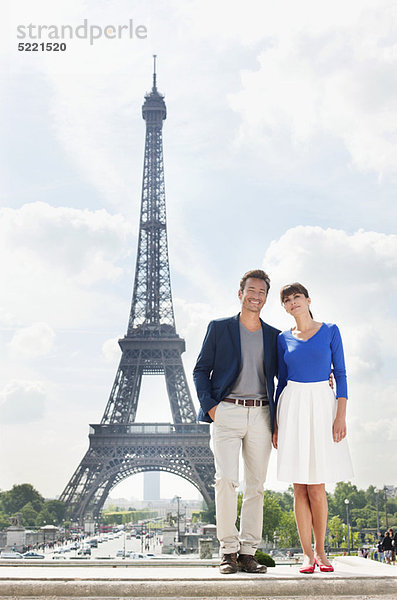 Paar steht zusammen mit dem Eiffelturm im Hintergrund  Paris  Ile-de-France  Frankreich