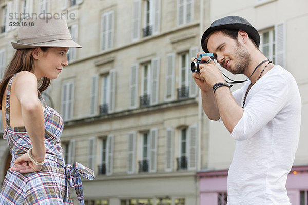 Mann beim Fotografieren einer Frau mit der Hand auf der Hüfte  Paris  Ile-de-France  Frankreich