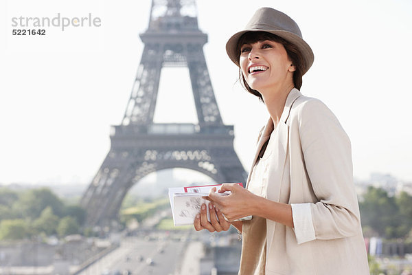 Frau mit einem Reiseführer mit dem Eiffelturm im Hintergrund  Paris  Ile-de-France  Frankreich