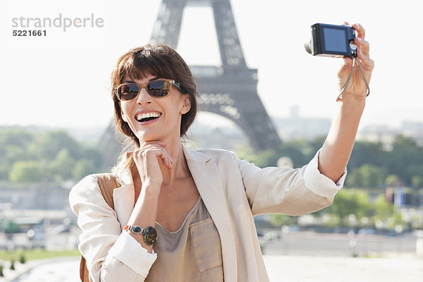 Frau beim Fotografieren mit dem Eiffelturm im Hintergrund  Paris  Ile-de-France  Frankreich