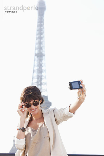 Frau beim Fotografieren mit dem Eiffelturm im Hintergrund  Paris  Ile-de-France  Frankreich