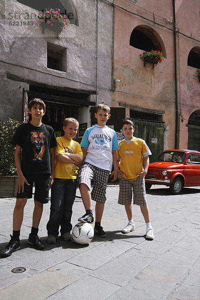 Freunde posiert mit Fußball In Street